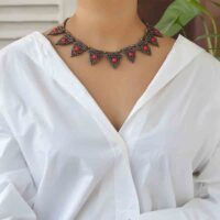 Model wearing macrame shell choker with brass and beads